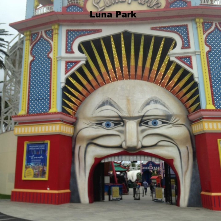 a large building in the background with Luna Park, Melbourne in the background