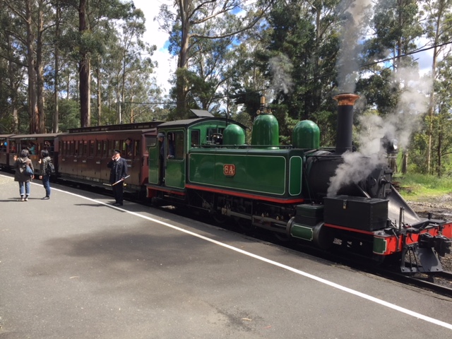a steam train is parked on the side of a road