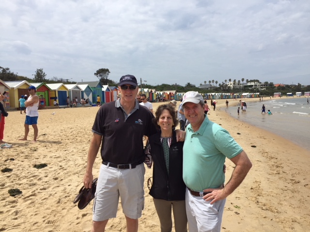 a group of people standing on top of a sandy beach