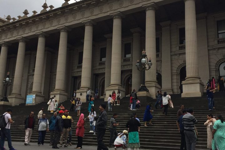 a group of people walking in front of a building